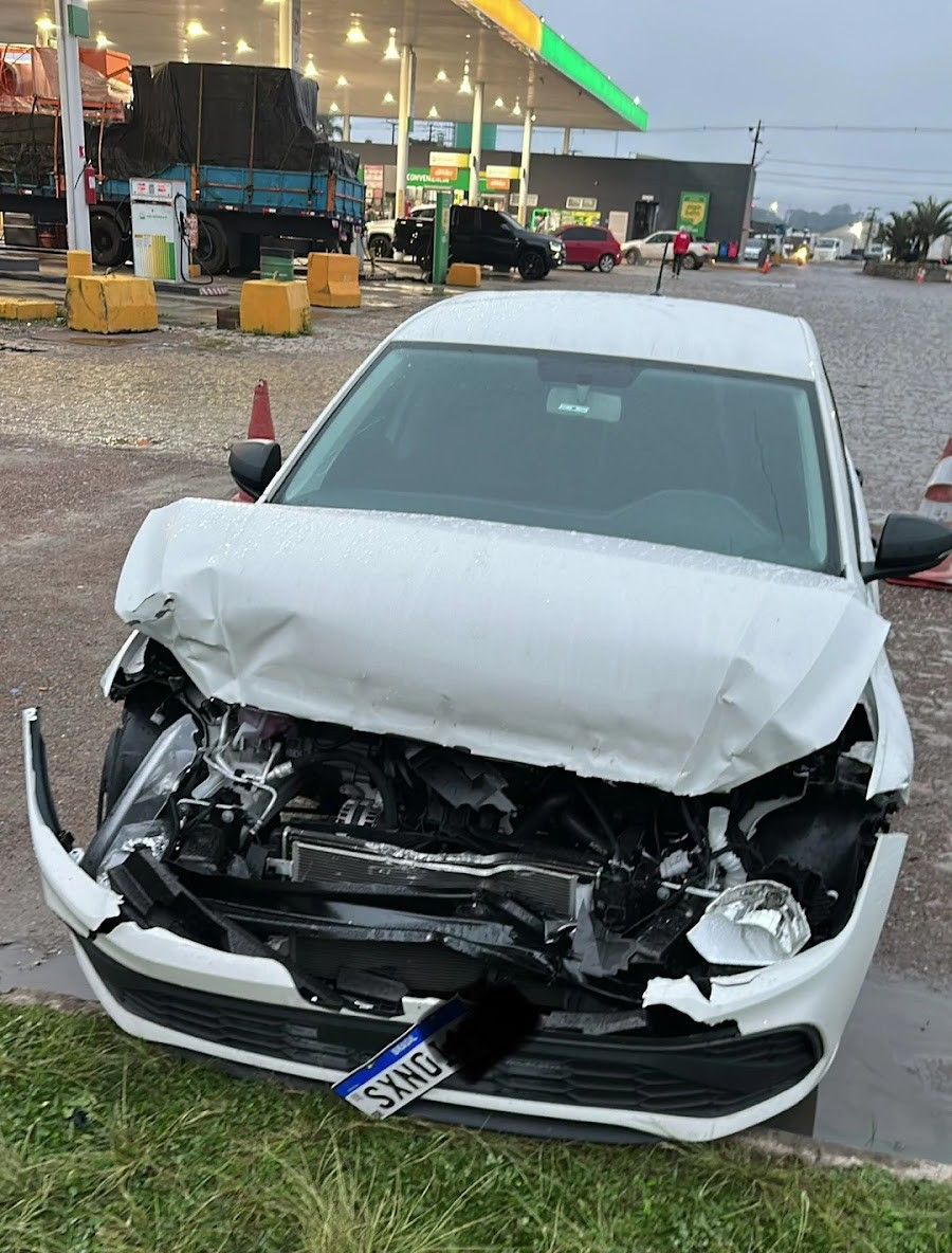 Carro branco com dano severo na frente antes do reparo de funilaria