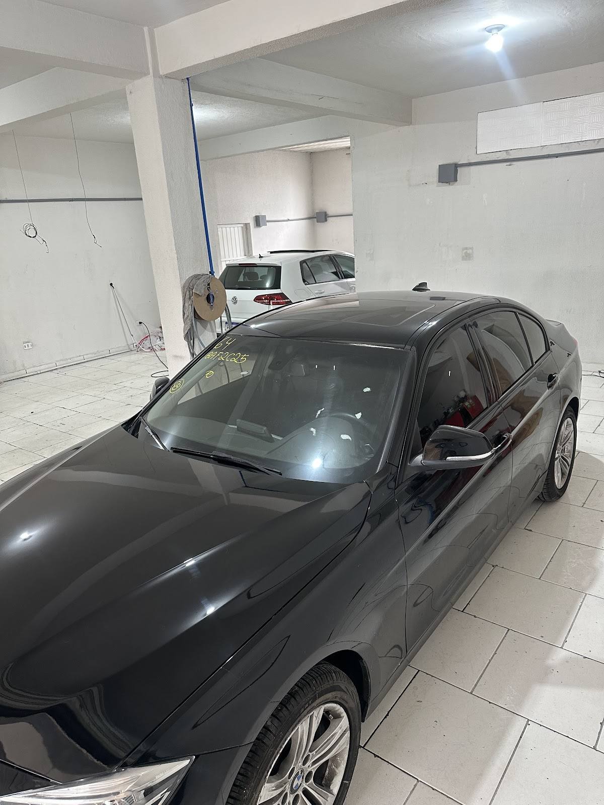 BMW preto polido dentro da oficina Vettel após o reparo
